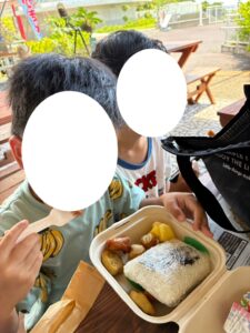 屋根のあるパーラーでお弁当を食べる子どもたち